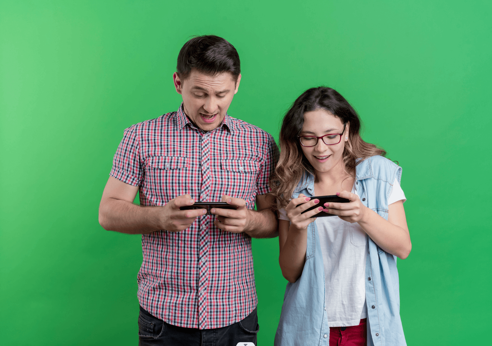 young-couple-man-woman-casual-clothes-holding-smartphones-playing-game-standing-green-wall